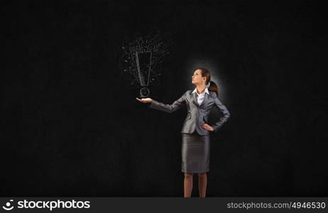 Young businesswoman holding exclamation mark in palm. Exclamation mark