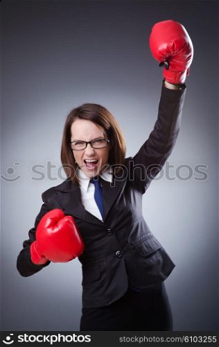 Young businesswoman in boxing concept