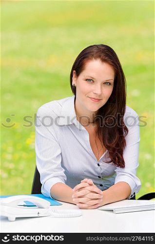 Young businesswoman in nature attractive look sitting behind table