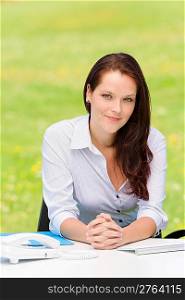 Young businesswoman in nature attractive look sitting behind table