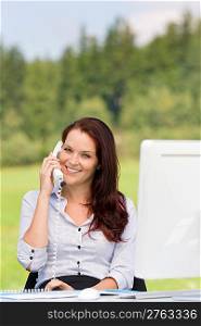 Young businesswoman in nature attractive smiling calling sitting behind table