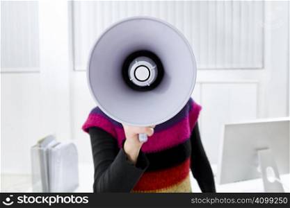 young businesswoman in office talking on the megaphone