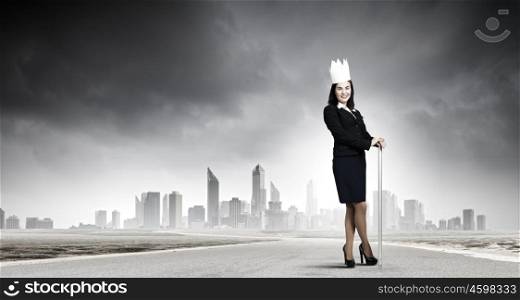 Young businesswoman in paper crown against city background