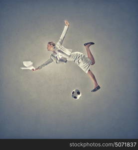 Young businesswoman in suit hitting soccer ball. Woman hit ball