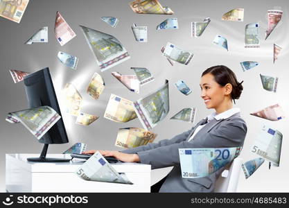 Young businesswoman in the office with money banknotes around her