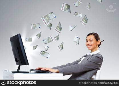 Young businesswoman in the office with money banknotes around her