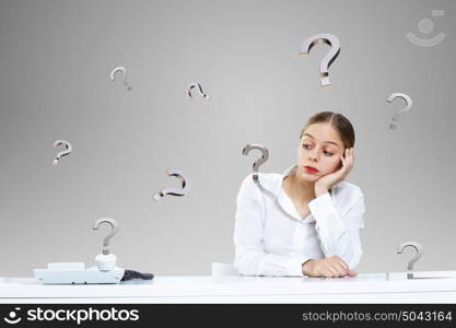 Young businesswoman in the office with money banknotes around her