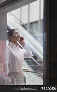 Young businesswoman inside the building talking on the phone