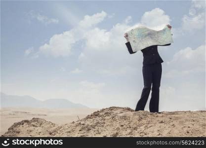 Young Businesswoman looking at a map in the middle of the desert