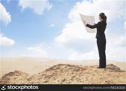 Young Businesswoman looking at a map in the middle of the desert