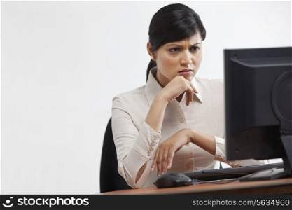 Young businesswoman looking at computer with full concentration