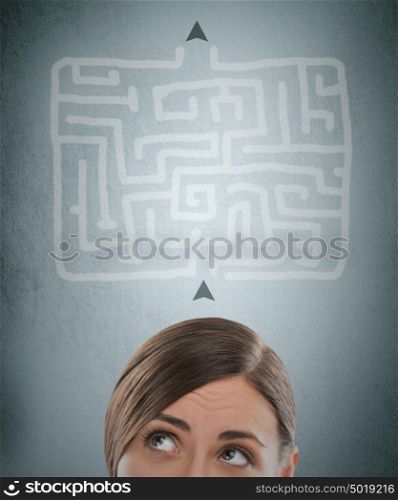 Young businesswoman looking at the labyrinth and thinking about right way
