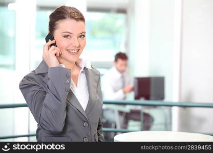 Young businesswoman making a call in the office