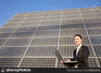 Young Businesswoman on Laptop in front of Solar Panel