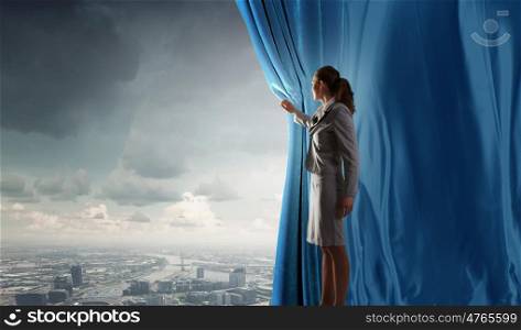 Young businesswoman opening stage curtain to another reality. Open new opportunities
