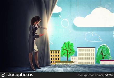 Young businesswoman opening stage curtain to another reality. Opened curtain