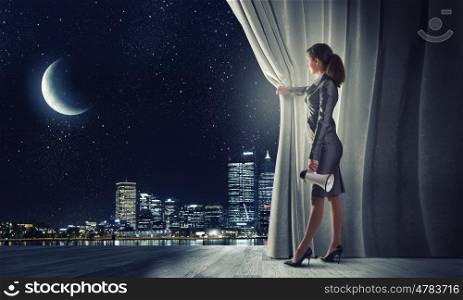 Young businesswoman opening stage curtain to another reality. Opened curtain