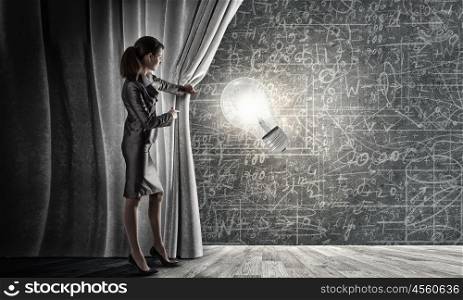 Young businesswoman opening stage curtain to another reality. Presenting idea