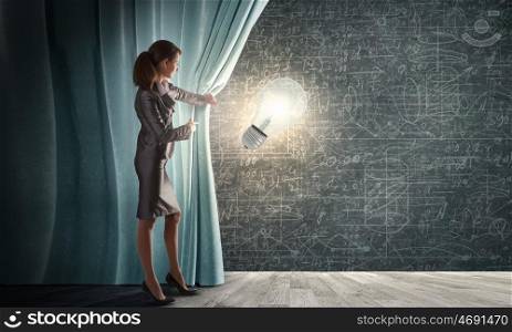 Young businesswoman opening stage curtain to another reality. Presenting idea