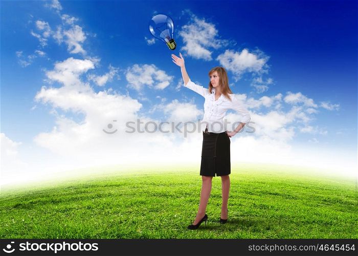 Young businesswoman outdoor with a bulb as a symbol of creative thinking