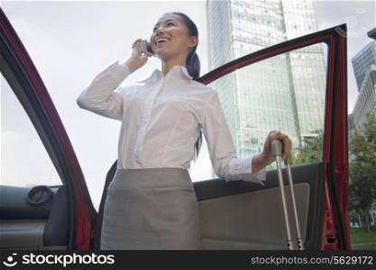 Young Businesswoman outside of her car talking on the phone