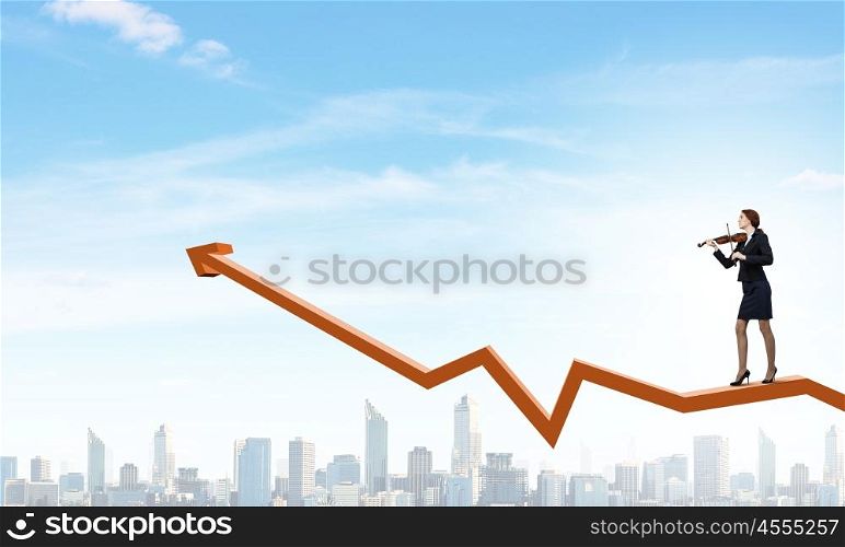 Young businesswoman playing violin and financial graphs at background. Melody of success