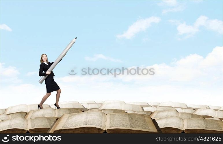 Young businesswoman pointing up with big pencil. Big professional