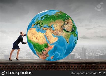 Young businesswoman pushing Earth planet. Elements of this image are furnished by NASA. Planet in danger