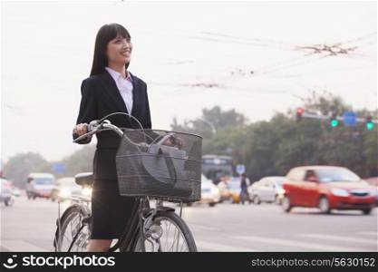 Young businesswoman riding a bicycle on the street, Beijing