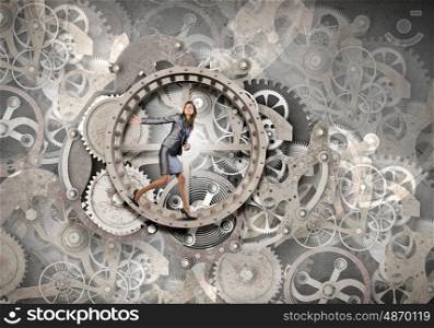 Young businesswoman running in wheel of gears mechanism. Always busy at work