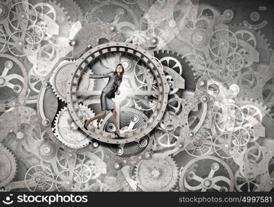 Young businesswoman running in wheel of gears mechanism. To turn as squirrel in wheel