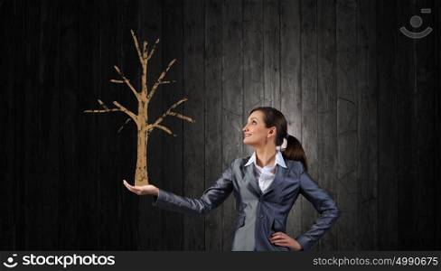 Young businesswoman showing money tree in her hand. Money tree