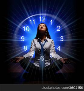 Young businesswoman sitting against blue background with clock interface