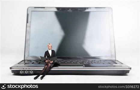 Young businesswoman sitting on a laptop, isolated on white