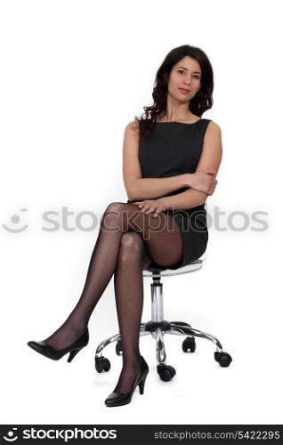 Young businesswoman sitting on an armchair, studio shot