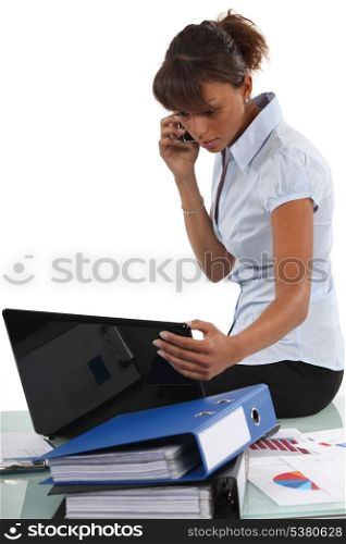 Young businesswoman sitting on desk