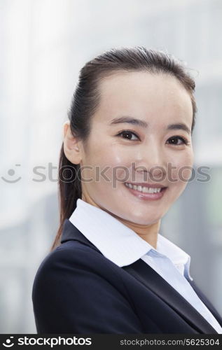 Young Businesswoman Smiling and Looking At Camera Urban Setting