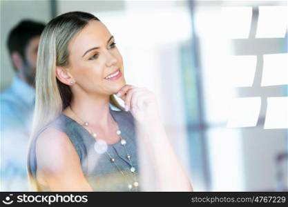 Young businesswoman standing and looking at notes