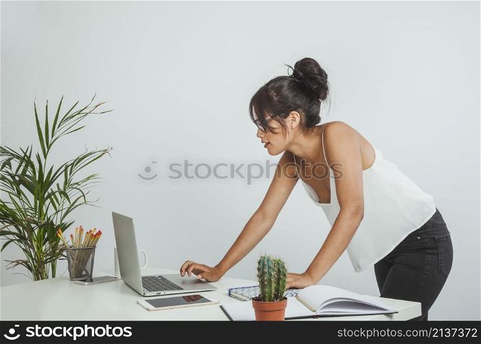 young businesswoman standing up working with laptop