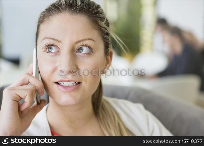 Young businesswoman talking on cell phone in office