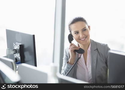 Young businesswoman talking on telephone in office