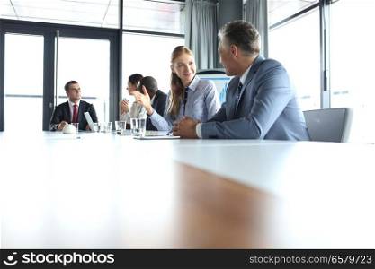 Young businesswoman talking with male colleague in meeting room