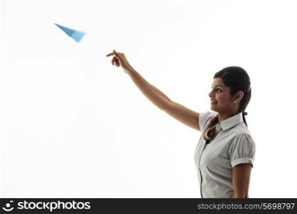 Young businesswoman throwing airplane on white background