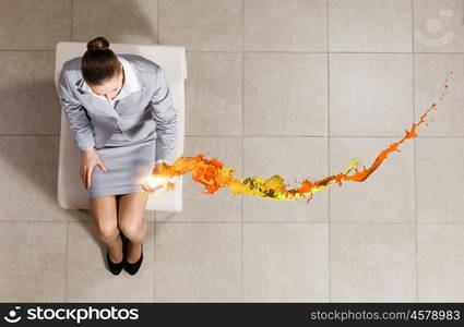 Young businesswoman. Top view of businesswoman sitting on chair with mobilephone in hand