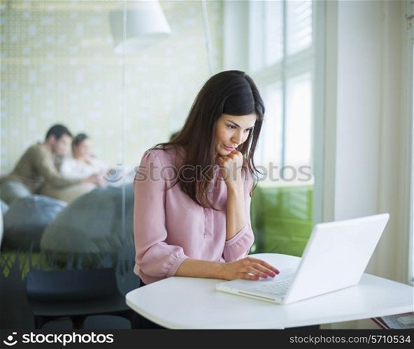 Young businesswoman using laptop at the office