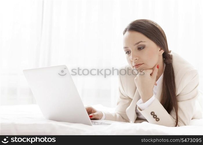 Young businesswoman using laptop in hotel room