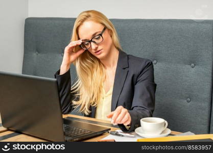 Young businesswoman using laptop sitting at the table in a cafe. Young businesswoman using laptop in cafe