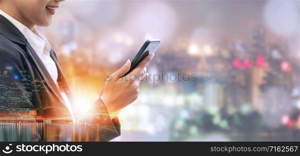 Young businesswoman using mobile phone with modern city buildings background. Future telecommunication technology and internet of things ( IOT ) concept.. Internet of things - Telecommunication Technology