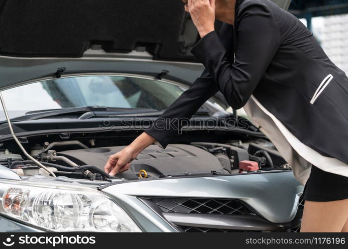 Young businesswoman whose car breakdown uses mobile phone to call for roadside assistance service. Travel and transportation vehicle problem.