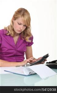 young businesswoman with calculator looking concentrated